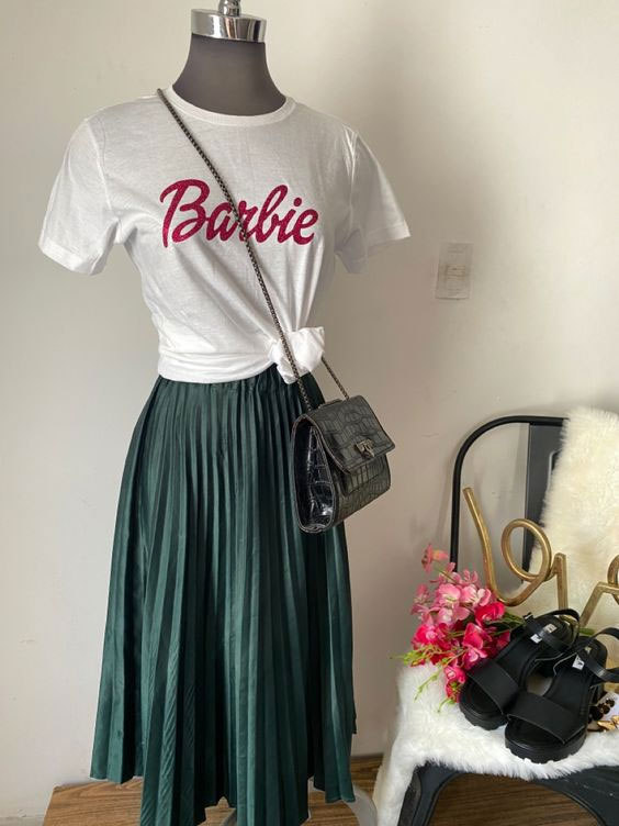 Puedes llevar una blusa con el logo de la muñeca y una falda plisada. Complementa con un bolso y unas sandalias de plataforma. Foto: Especial